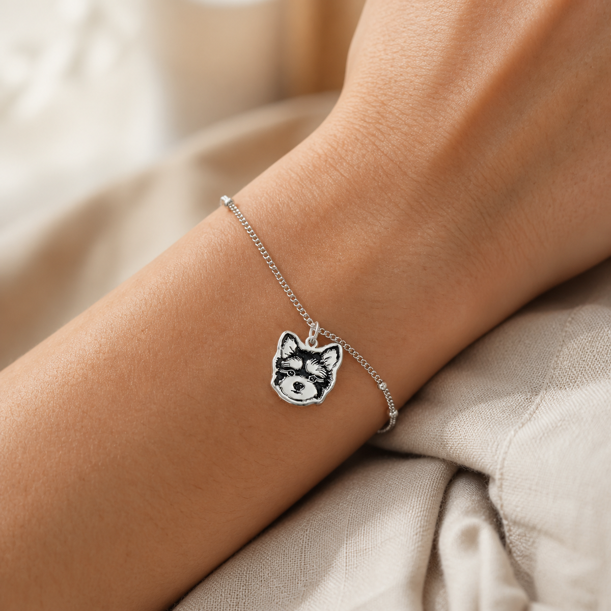 Styling illustration of a silver pet portrait bracelet worn on a wrist